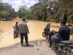 Personil Polsek Hulu Kuantan Memantau Banjir yang Merendam Puluhan Rumah Warga
